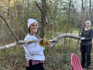 Emmelyn and Olivia clearing fallen brush at Riveted Retreat's 1962 Airstream site