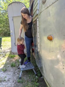 Emmelyn and her toddler daughter climbing into their Airstream